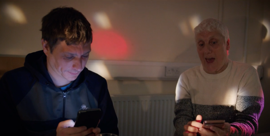 Two people texting - from a video still.